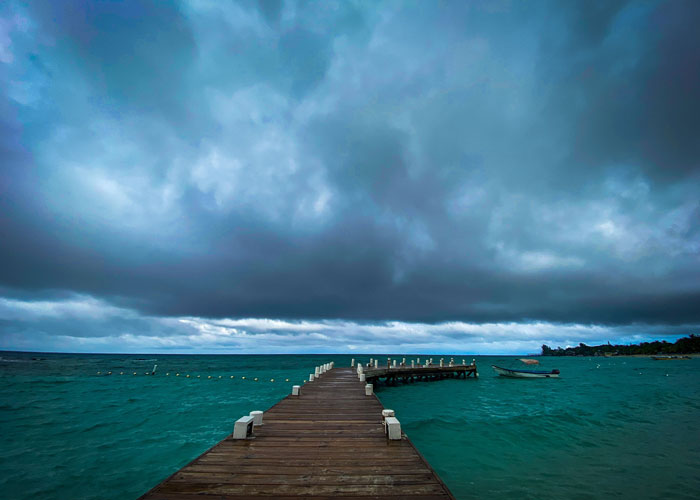 Show a dock on Roatan and past it stormy weather